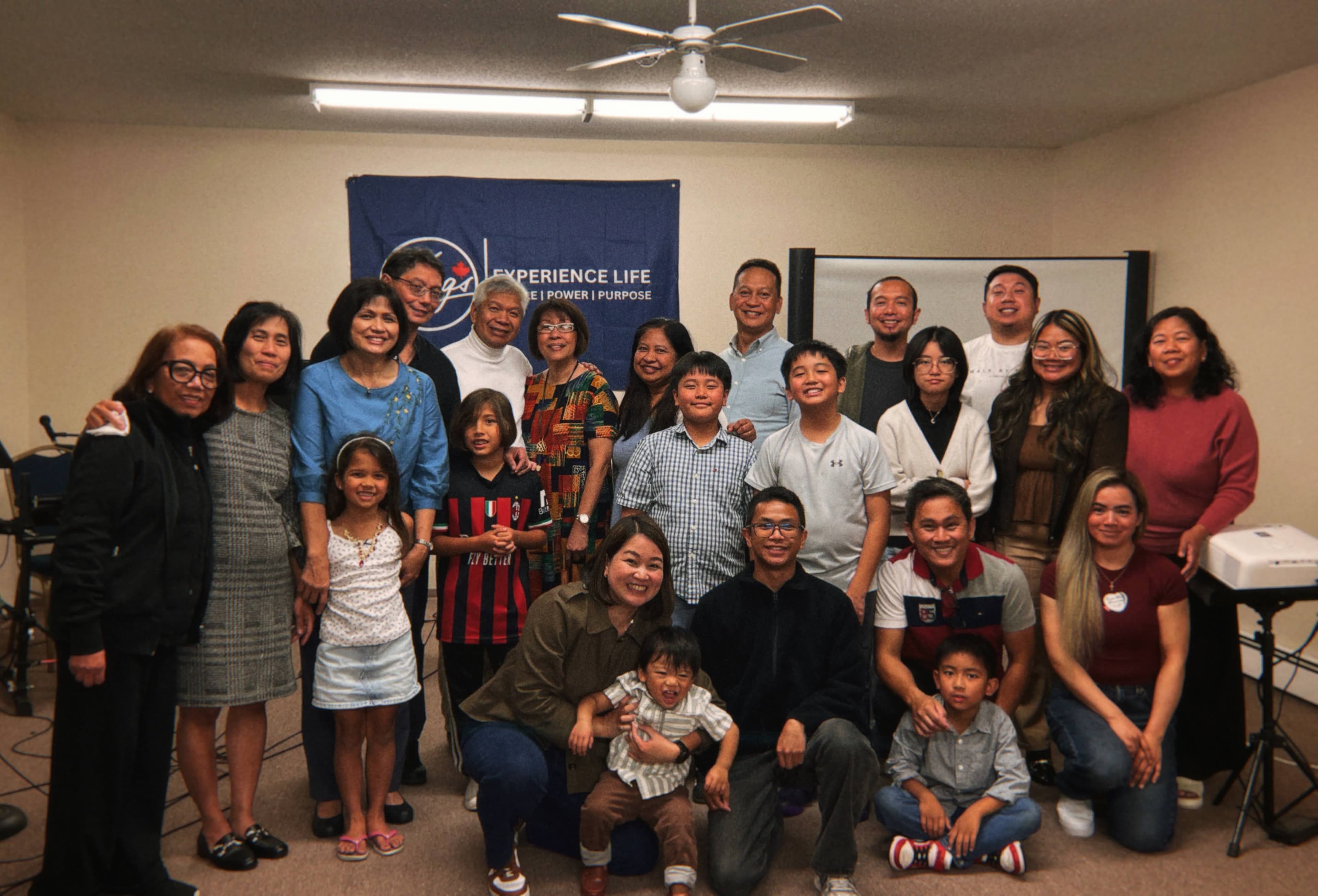 Adults and children gathered for a church-family group photograph