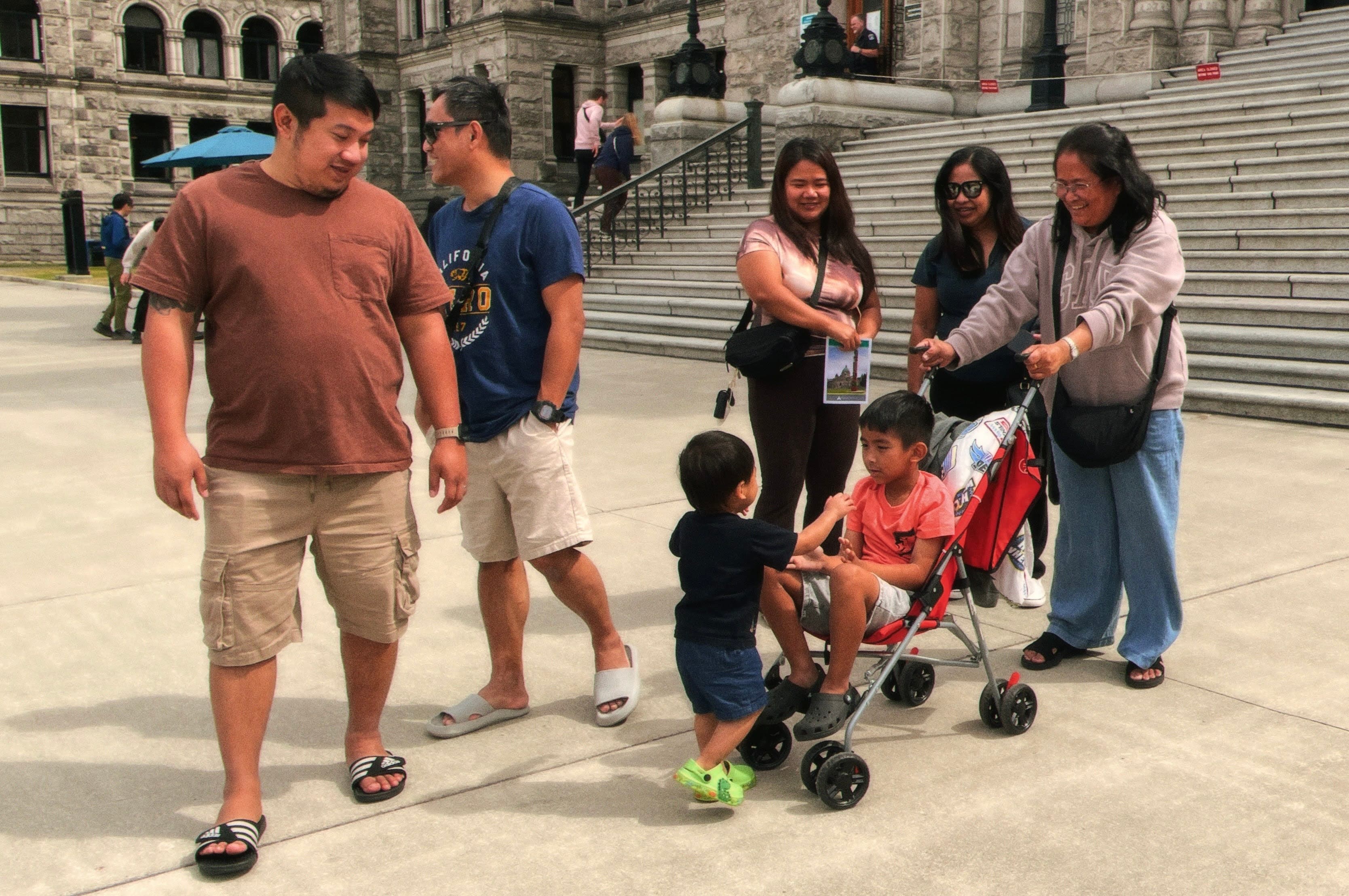 Adults and children spending time together outside a stone building